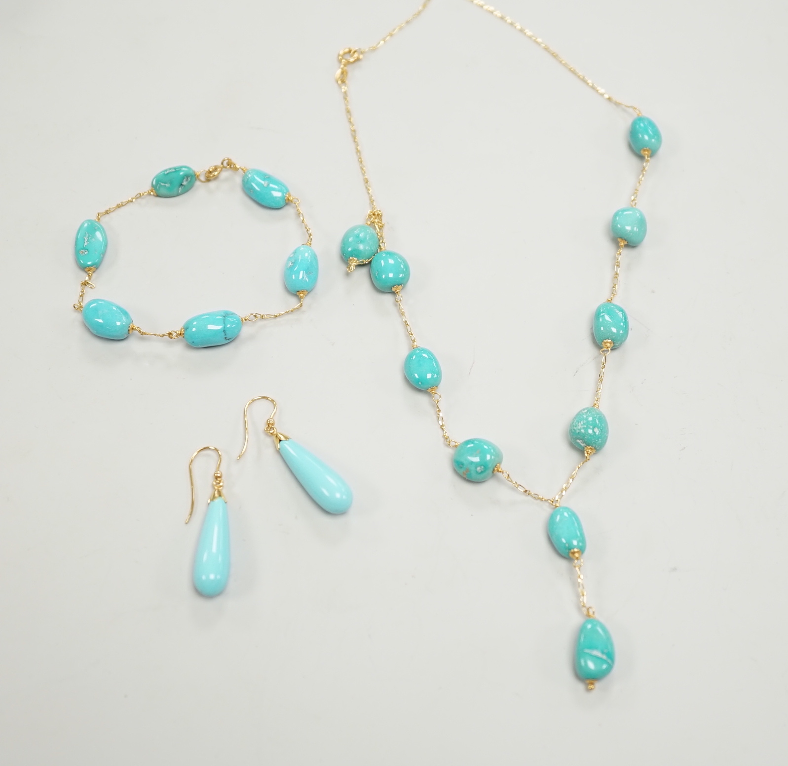 A modern Italian 750 and turquoise bead set necklace and matching bracelet, (necklace knotted) and a pair of similar enamelled? earrings, gross weight 29.4 grams.
